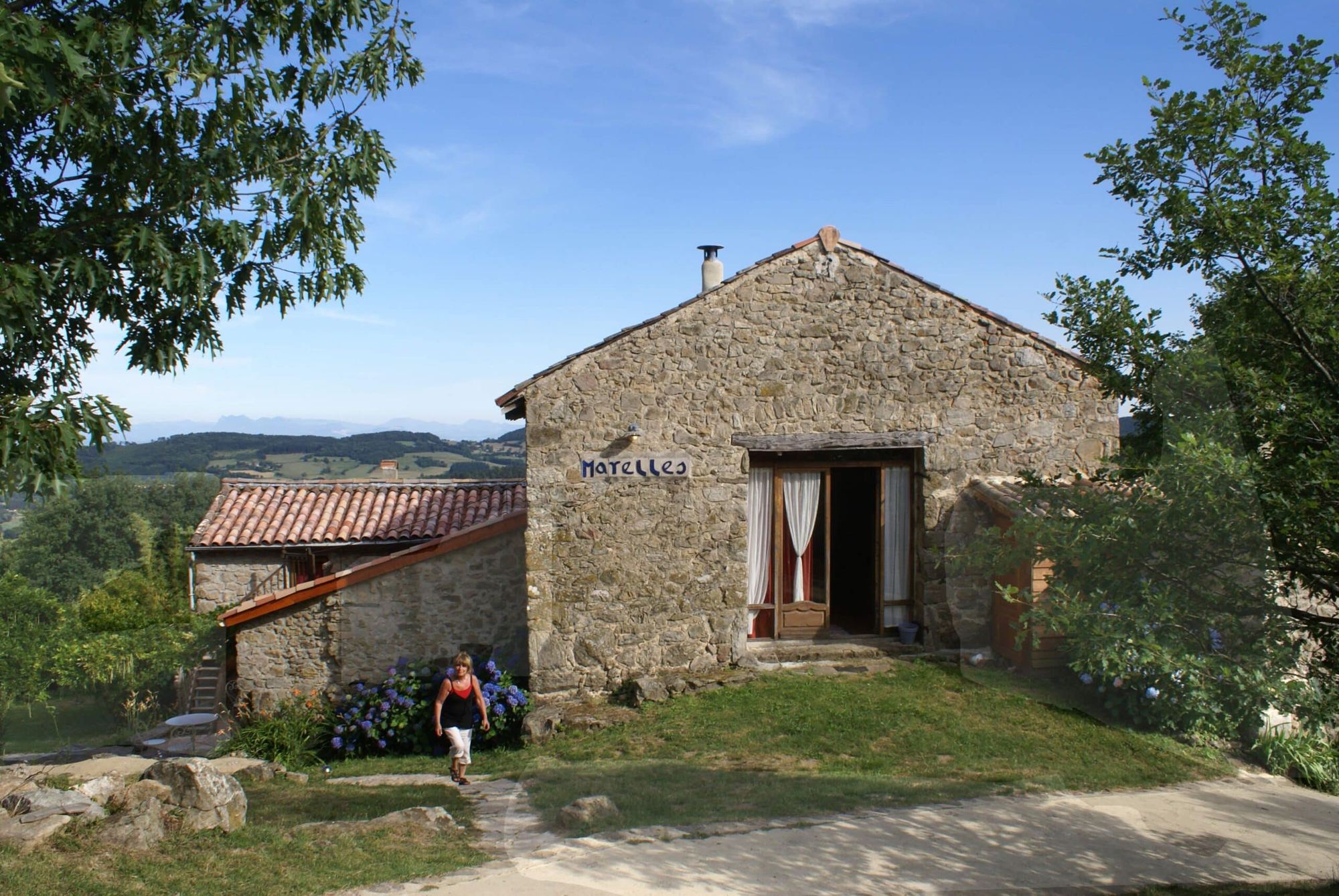 Une maison de pierre du hameau, face aux collines