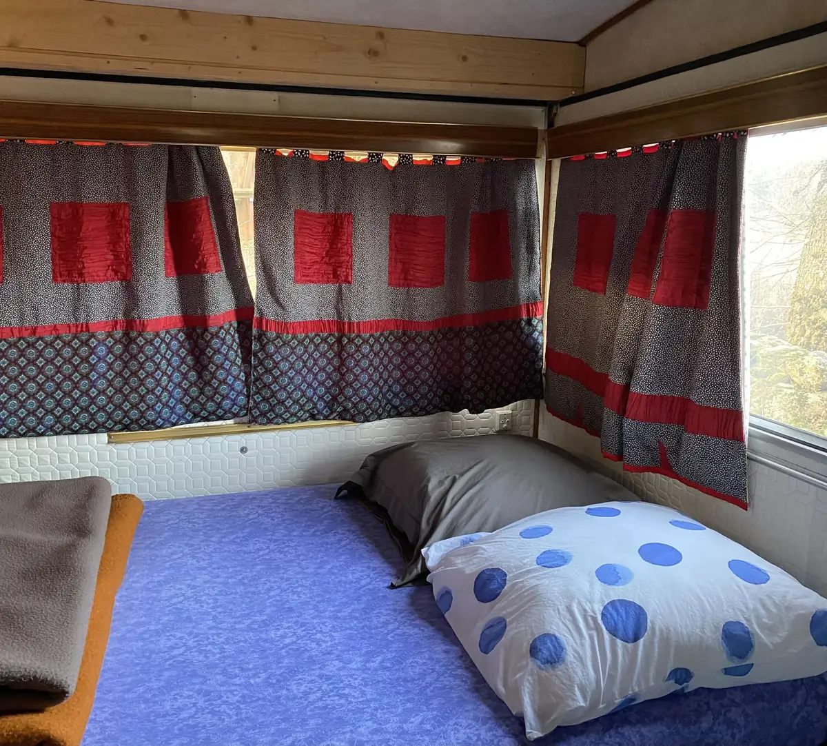 L'intérieur d'une caravane, rideaux rouges et coussins à pois