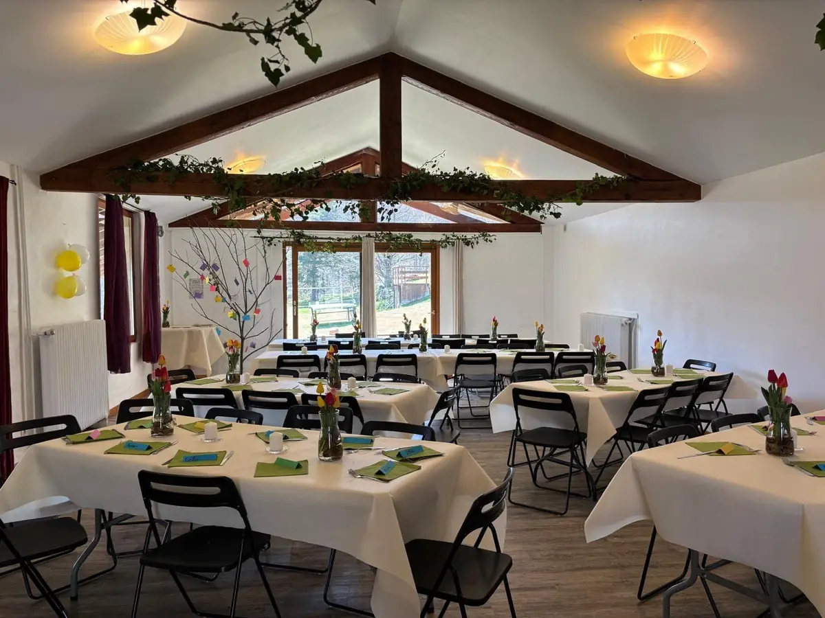 La Salle du Haut dressée pour une fête, tables nappées et guirlandes sous la charpente